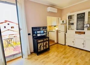 a living room with a kitchen and a refrigerator at Civico 22 in Fiumicino