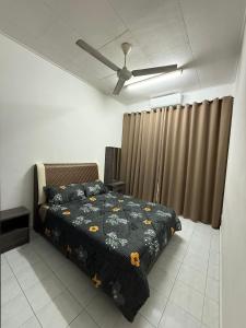 Un dormitorio con una cama y un ventilador de techo. en J&N Homestay, en Skudai