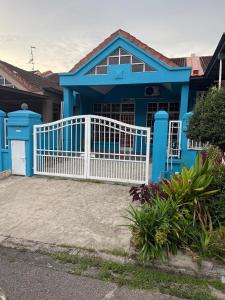 una casa azul con una valla blanca en J&N Homestay, en Skudai