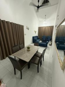 Una mesa de comedor y sillas en una sala de estar. en J&N Homestay, en Skudai