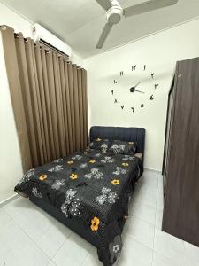 a bedroom with a bed and a clock on the wall at J&N Homestay in Skudai