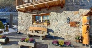 a stone building with a bench in front of a window at Hotel Chalet val di Rabbi in Rabbi +37 photos