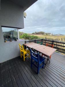 a wooden deck with a wooden table and chairs at Ostende frente al mar in Ostende