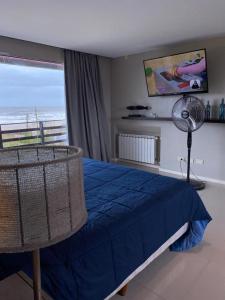 a bedroom with a blue bed with a fan and a window at Ostende frente al mar in Ostende
