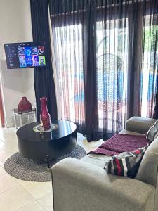 a living room with a table and a couch at Cozy pool side cottage in Roodepoort