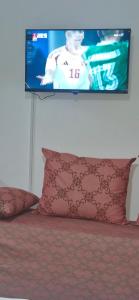 a tv on a wall above a bed with a pillow at Appartement Océan in Rabat
