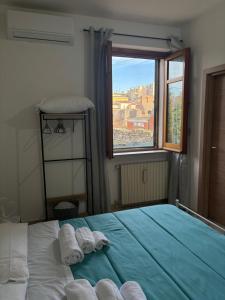 ein Schlafzimmer mit einem Bett, auf dem zwei Handtücher liegen in der Unterkunft La Finestra sul Teatro Romano in Benevento