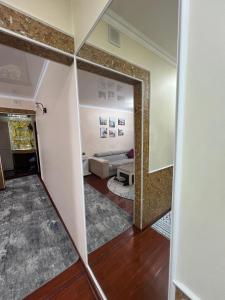 a room with a mirror and a living room at 3х комнатная квартира in Shymkent +3 photos