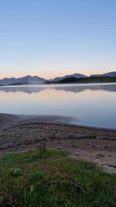 una gran masa de agua con montañas al fondo en Mor's hus, en Vestvågøya