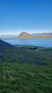 un gran campo con una gran masa de agua en Mor's hus, en Vestvågøya