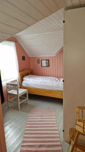 una pequeña habitación con una cama y una silla en Mor's hus, en Vestvågøya