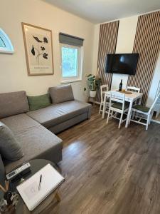 a living room with a couch and a table at Offline vendégház in Orfű