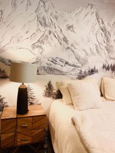 1 dormitorio con un mural de montaña en la pared en Chalet de luxe contemporain vue 360 degrés sur les montagnes, en Guchan