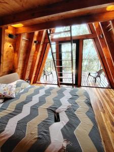 a bed in a room with a large window at Refugios de Altaguita in Suesca