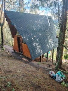 a small cabin with a pitched roof in the woods at Refugios de Altaguita in Suesca