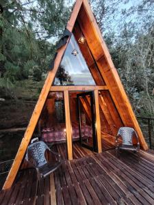 a cabin with a glass door and two chairs on a deck at Refugios de Altaguita in Suesca