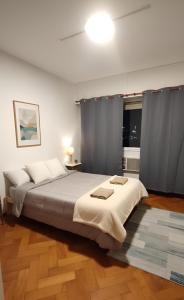 Hermoso departamento con vista a Obelisco lV في بوينس آيرس: غرفة نوم بها سرير كبير عليه منشفتين