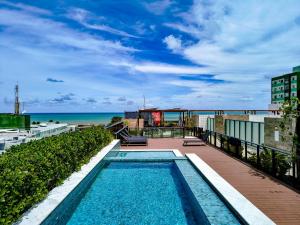 若昂佩索阿Cobertura com jacuzzi a 130m da praia de Tambaú的以海洋为背景的游泳池