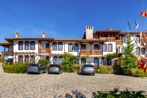 a large house with cars parked in front of it at Vacation Apartment in Starosel POOL & SPA in Starosel