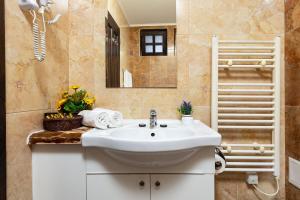 a bathroom with a white sink and a mirror at Vacation Apartment in Starosel POOL & SPA in Starosel +27 photos