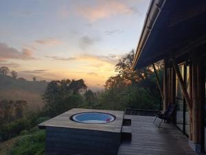 a deck with a hot tub on top of a house at Glamping Bosque de helechos, privacidad y cercanía in Manizales
