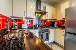 a kitchen with white cabinets and red tiles at City Centre 2BR2BA Balcony Apt@The CubeMailbox in Birmingham