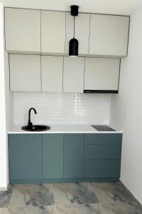 a kitchen with white cabinets and a sink at Mirabello in Itʼkhvisi