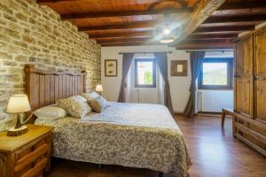 a bedroom with a bed and a brick wall at La Casa De Los Pedros in Villar +140 photos