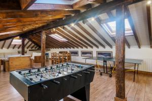 a ping pong table in a room with beams at La Casa De Los Pedros in Villar