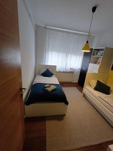 a small bedroom with a bed and a couch at Apartman Gaby in Virovitica