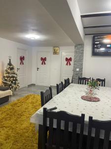 una sala da pranzo con un tavolo e un albero di Natale di Casa Andra si Denis a Novaci-Străini