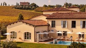 a house with a swimming pool in front of a vineyard at Borgo Conde Wine Resort in Forlì