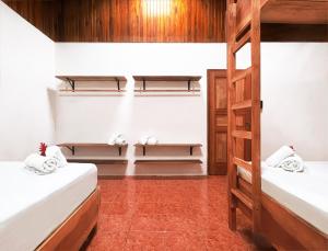 a room with two bunk beds and a ladder at ICO Living Hostel in Santa Teresa Beach