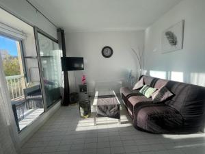 ein Wohnzimmer mit Sofa und Tisch in der Unterkunft Grand studio au Grau-du-Roi proche Seaquarium et plage in Le Grau-du-Roi
