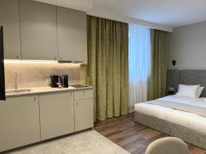a bedroom with a bed and a kitchen with a sink at Apartamenty Delecta in Krakow