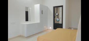 Una habitación blanca con una mesa y un espejo. en AZURE stay happy, en Pudunagaram