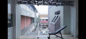 Una silla en un balcón con vista a una calle. en AZURE stay happy, en Pudunagaram 15 fotos más