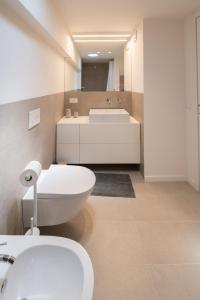a bathroom with a white toilet and a sink at Sarius Relais in Seriate