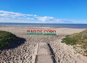 een strand met een bord waarop momo staat bij Casa en Mar de Cobo in Mar de Cobo
