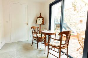 een eetkamer met een tafel, stoelen en een klok bij Les Flobarts - grande maison de famille en centre ville à 50m de la baie in Saint-Valery-sur-Somme