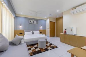 Un dormitorio con una cama blanca y una cocina. en hotel monville akota, en Vadodara