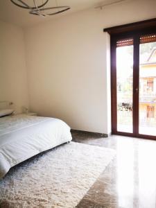 Rossi apartment في Mentana: غرفة نوم بها سرير ونافذة كبيرة