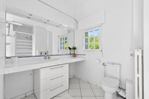 a white bathroom with a toilet and a sink at Villa Séquoia Saint-Germain-en-Laye in Saint-Germain-en-Laye +14 photos