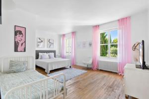 a white bedroom with two beds and a window at Villa Séquoia Saint-Germain-en-Laye in Saint-Germain-en-Laye