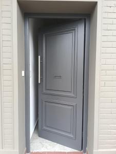 オラバリアにあるDepartamento céntrico planta bajaの白いレンガ造りの建物にある灰色のドア