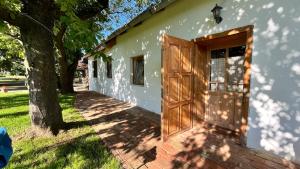 a white building with a door and a tree at Rustic Harmony in Abádszalók