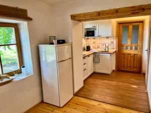 a kitchen with a white refrigerator and wooden floors at Rustic Harmony in Abádszalók +15 photos