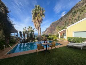 un patio con tavolo e sedie accanto alla piscina di Suite Bela Vigia 3 a Jardim do Mar
