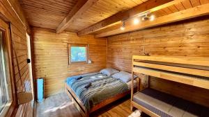 a small room with a bed in a wooden cabin at Rustic Harmony in Abádszalók