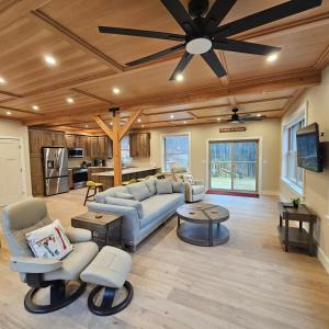 Powder Run - Modern 3BR Basecamp with Hot Tub, AC, EV Charger & Flat Parking في North Sherburne: غرفة معيشة مع أريكة ومروحة سقف